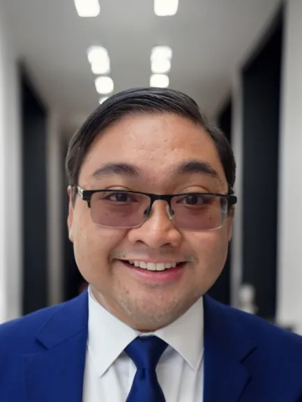 John Villanueva smiling in a blue suit